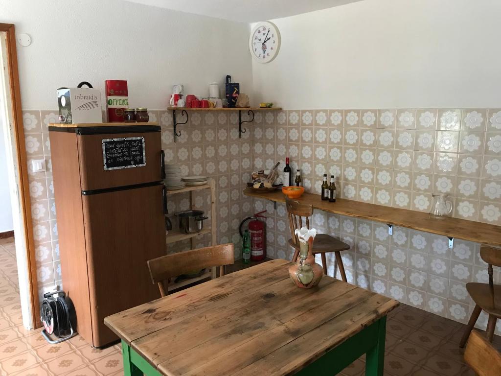 蓬泰巴Ostello Casa Morit的厨房配有木桌和冰箱。