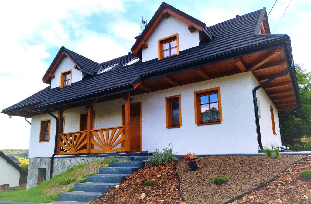米卢夫卡Beskidzka Chałupa的黑色屋顶的白色房子