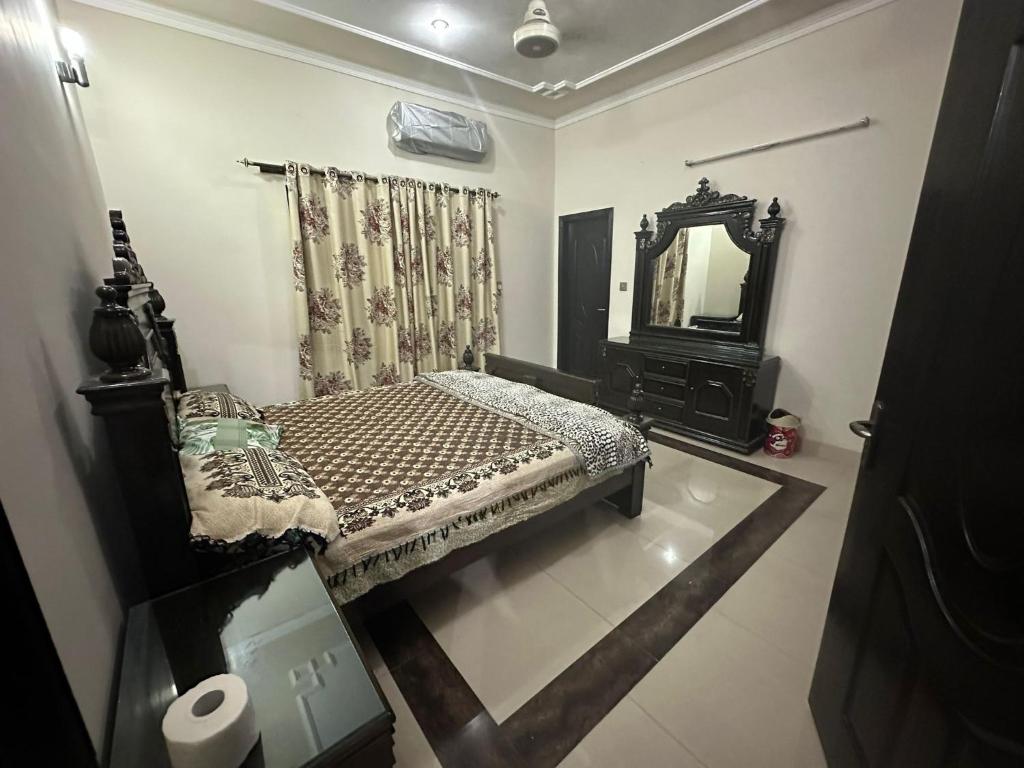 拉合尔Bahria Town - 10 Marla 2 Bed rooms Portion for families only的一间小卧室,配有一张床和镜子