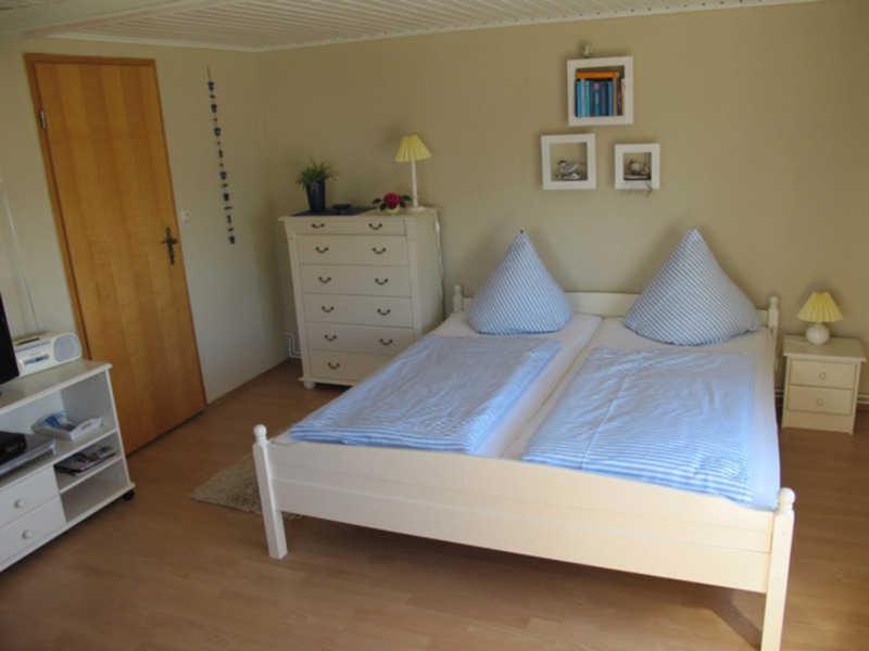 萨斯尼茨Ferienwohnung Stüber的一间卧室配有白色床和蓝色枕头