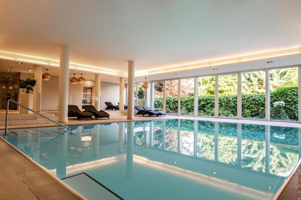 奥西亚歇尔湖畔施泰因多夫传奇公寓酒店的一座带大窗户的房屋内的游泳池