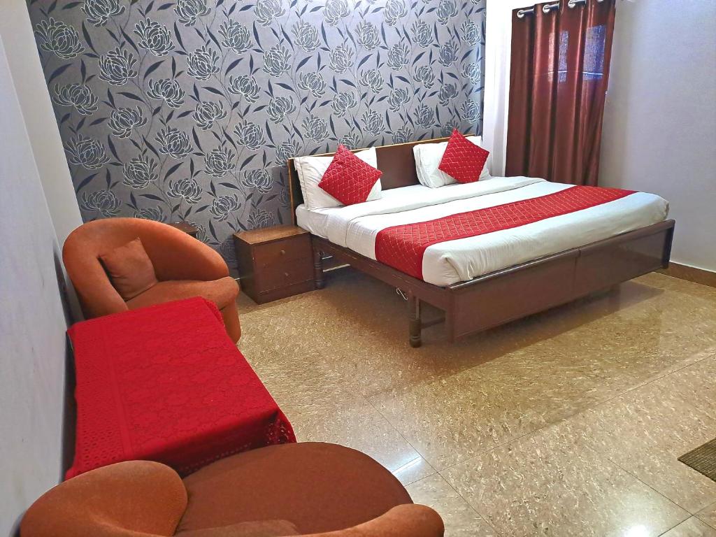 新德里Atlas Inn Guest House的一间卧室配有一张床、一把椅子、一张床和一张沙发