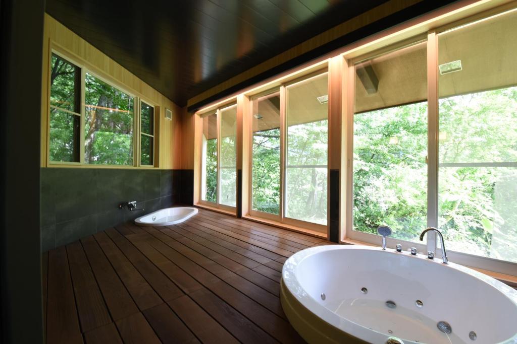 山形市ユニテ蔵王ジョーニダ リゾート的一间带大浴缸和窗户的浴室