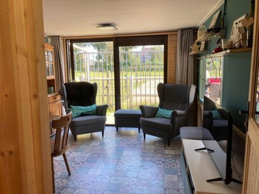 多德雷赫特Aan de Dijk的客厅配有椅子、沙发和桌子