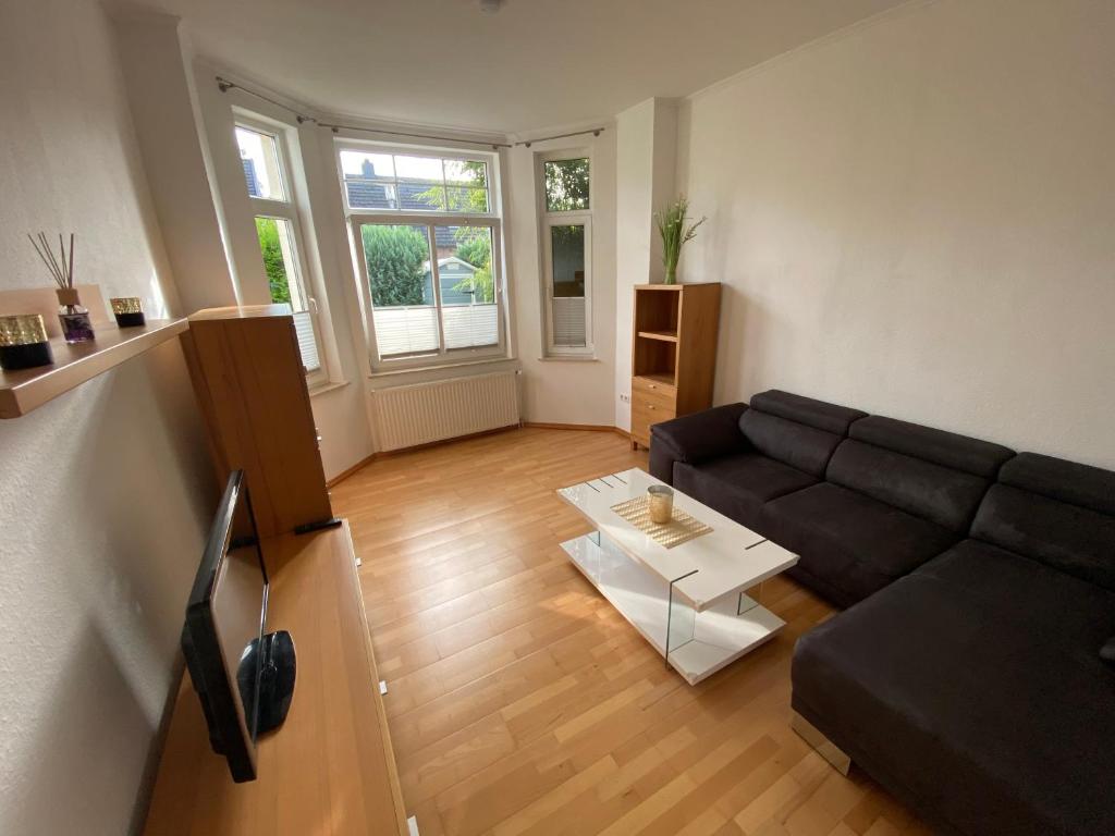 奥尔登堡Apartment in guter Lage für bis zu 5 Personen的客厅配有黑色沙发和桌子