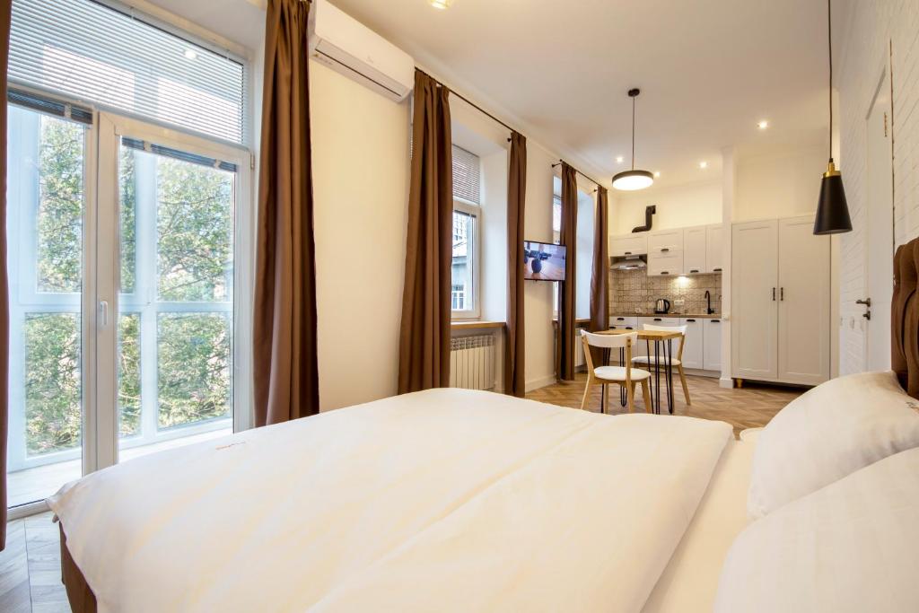 基辅Idea Design Apart-Hotel Chykalenka的卧室配有白色的床和桌子