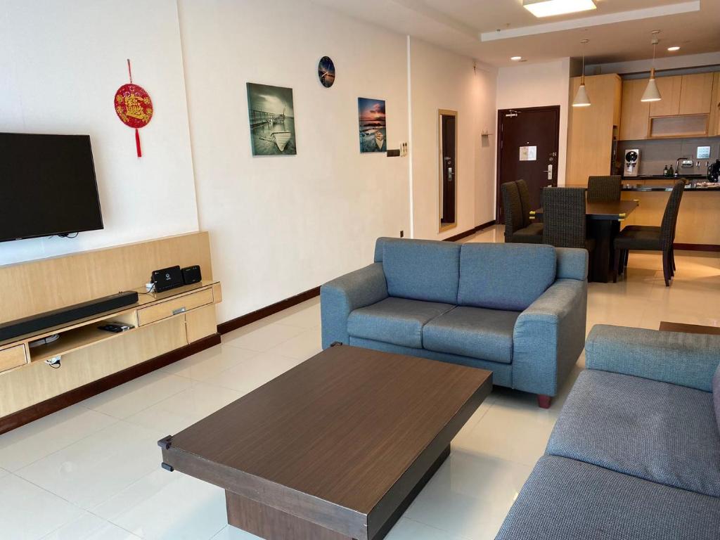 古晋The Floorspace Imperial Suites Apartment的客厅配有2把蓝色椅子和电视