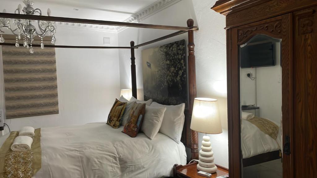 彼得马里茨堡Casa 57的一间卧室配有天蓬床和镜子