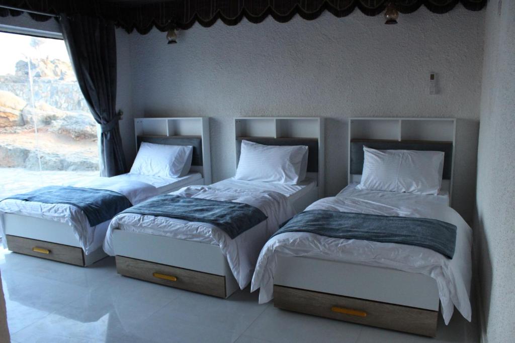 Sa‘ab Banī KhamīsAl khitaym guest house的卧室设有两张单人床和窗户。