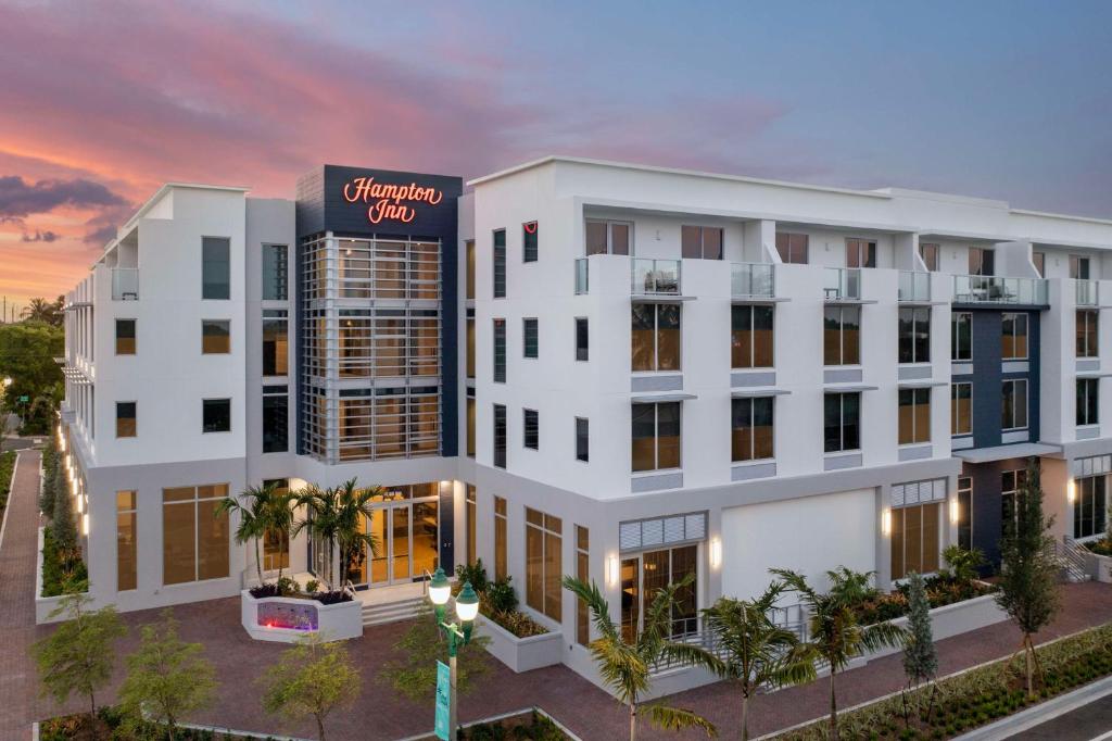 德尔雷比奇Hampton Inn Delray Beach的白色建筑外景,上面有标志