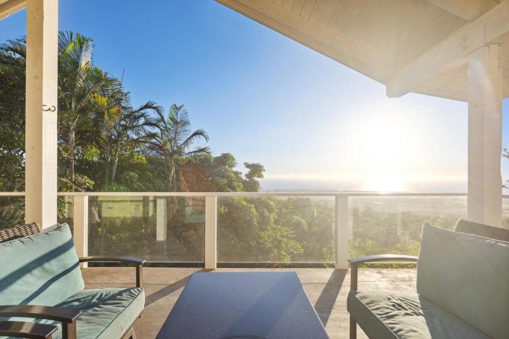 科纳Pu'ukala Sunset Estate with Amazing Ocean Views! home的一个带椅子和桌子的门廊,享有海景