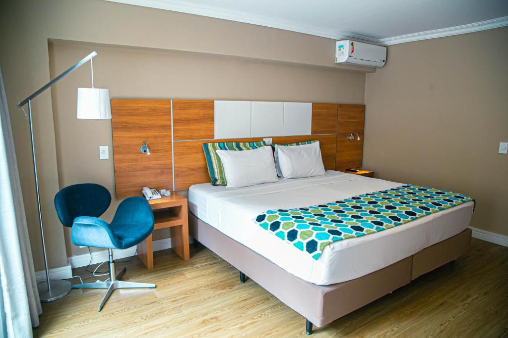 马卡埃Dubai Macaé by Atlântica的一间卧室配有一张床、一张桌子和一把椅子