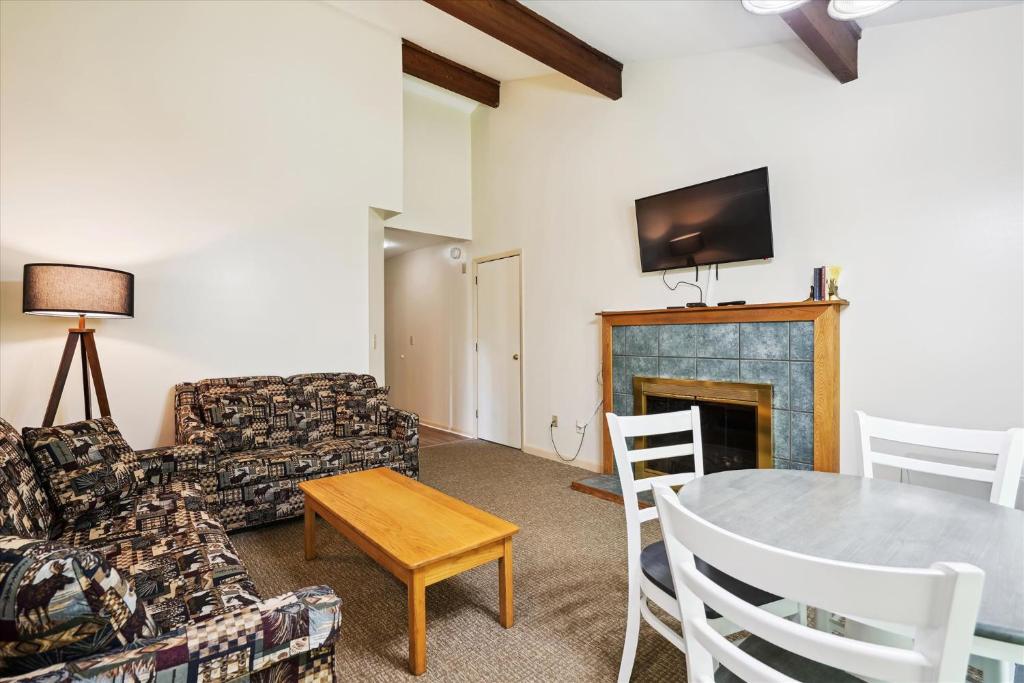 基灵顿Cedarbrook Queen Suite 106的客厅配有桌子和壁炉