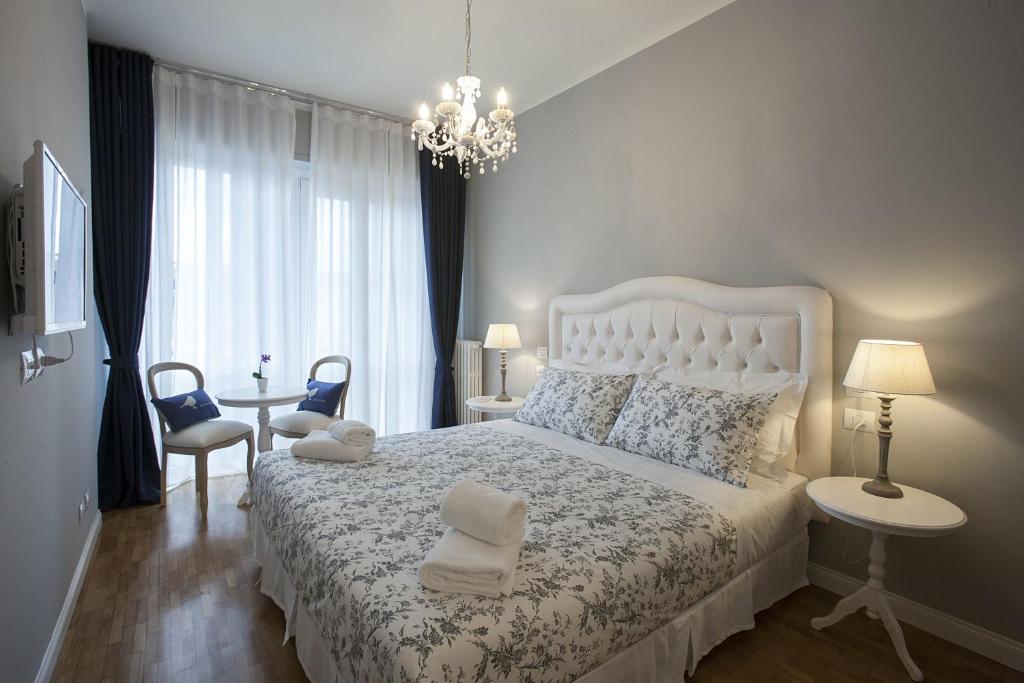 佛罗伦萨纳尼娜住宿加早餐旅馆的卧室配有白色的床和吊灯。