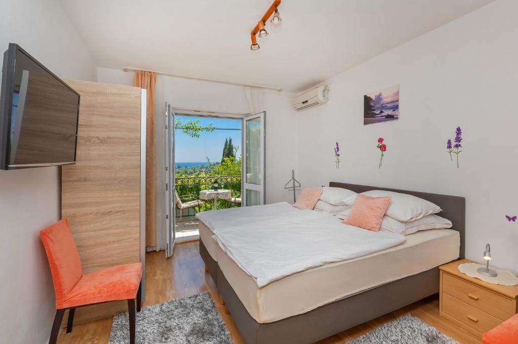 米利尼Apartments Galić的一间卧室配有一张床、一台电视和一个阳台