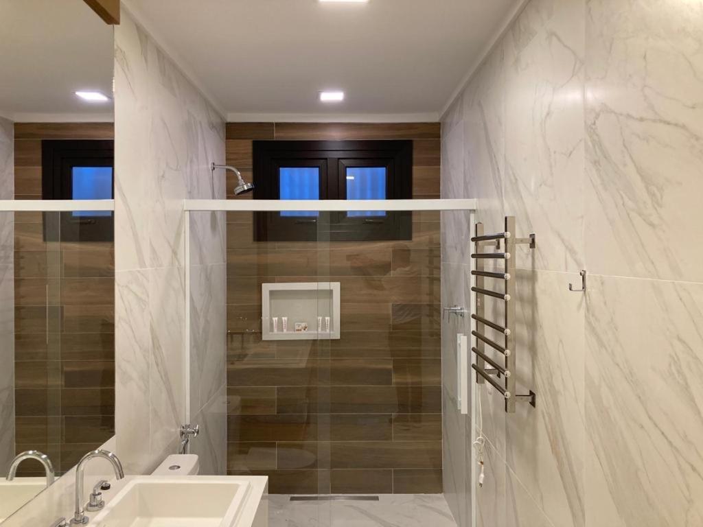 格拉玛多Austin Suites Gramado的一间带水槽和淋浴的浴室