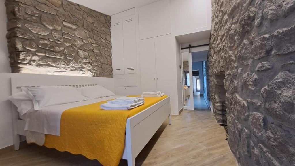 维托尔基亚诺Alloggio turistico Pietra Viva的一间卧室设有一张床和石墙