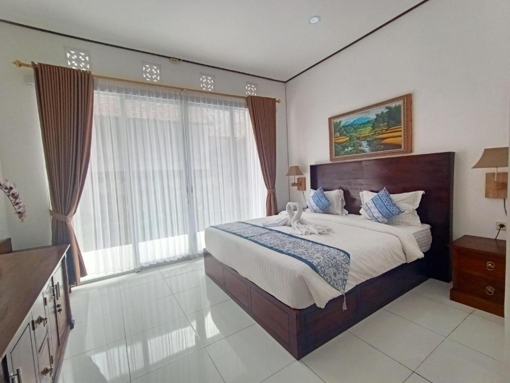 BangliEdu Hotel (Hotel Edukasi SMK PK)的一间卧室设有一张大床和一个大窗户
