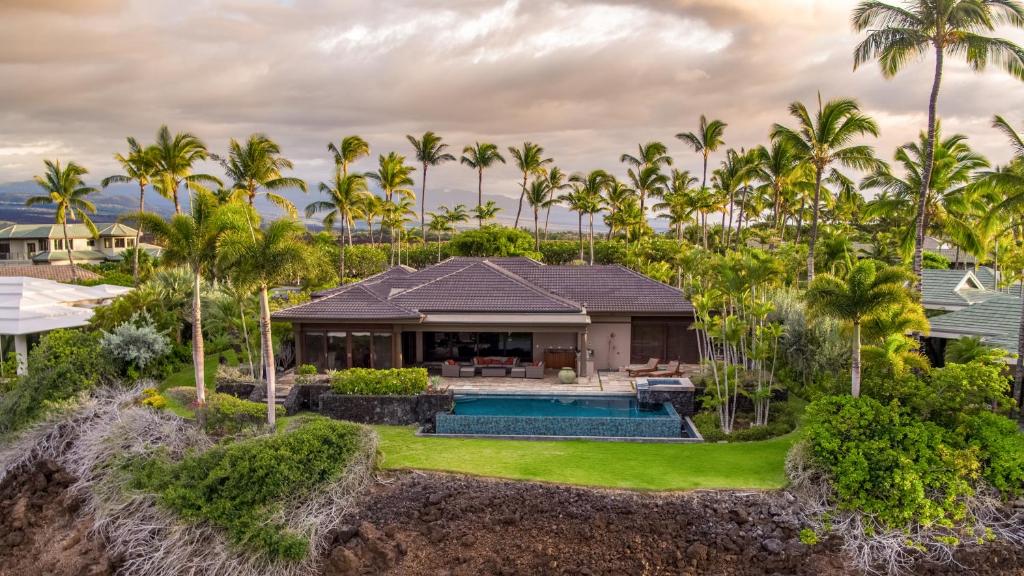 瓦克拉Mauna Lani Luxury Vacation Villas - CoralTree Residence Collection的享有带游泳池和棕榈树的别墅的空中景致