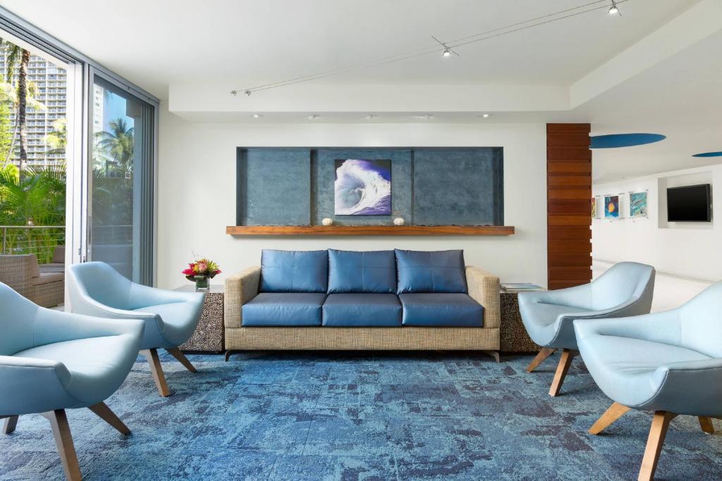 檀香山威基基海滩万怡酒店 的客厅配有蓝色的沙发和椅子