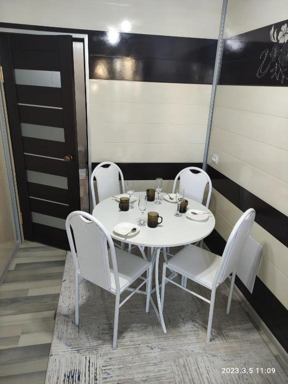 卡拉科尔Komfort Lux Centre Karakol的客房内的白色桌椅