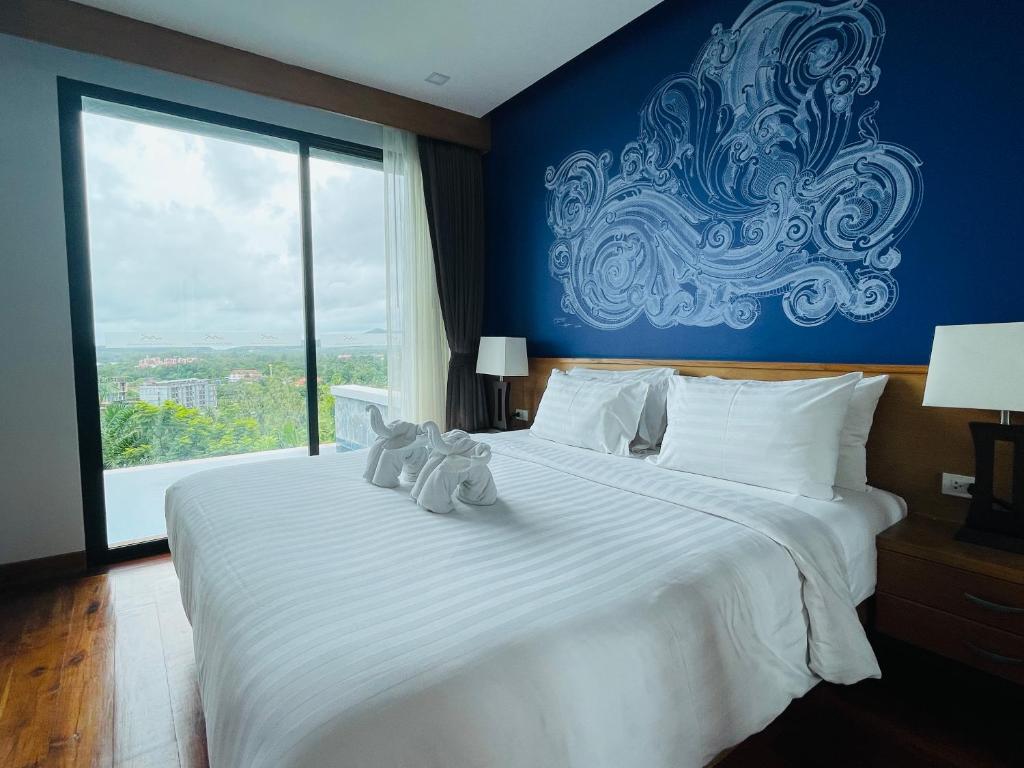 奥南海滩Aonang Suite Pool Villa的卧室配有一张白色大床,上面有两只填充动物