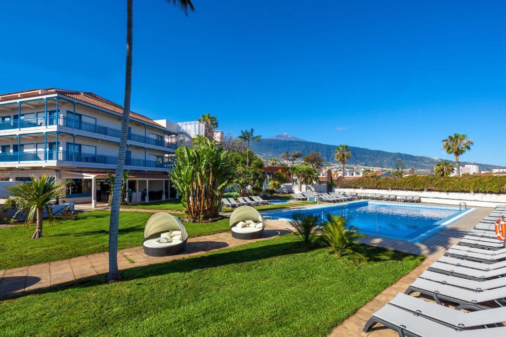 拉克鲁斯O7 Tenerife的一个带游泳池和躺椅的度假胜地