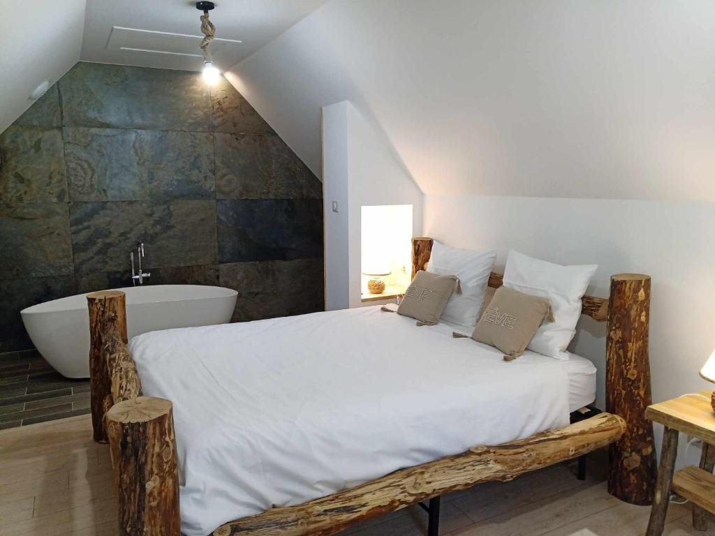 BoussièresGîtes de l'Orée du Bois的一间卧室设有一张大床和一个浴缸