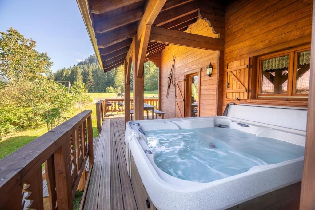 克松吕-隆日梅Les Griottes, véritable chalet de montagne, avec Jacuzzi et Sauna的木制甲板上的大型热水浴池