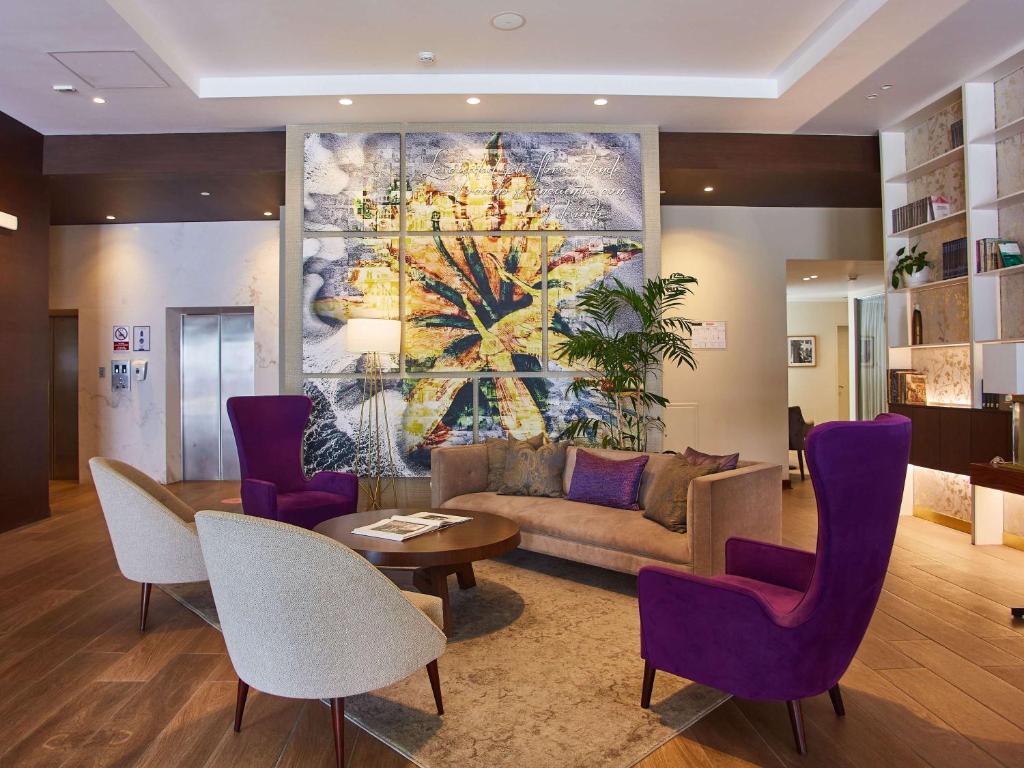 利马Manto Hotel Lima - MGallery的客厅配有沙发、桌子和紫色椅子