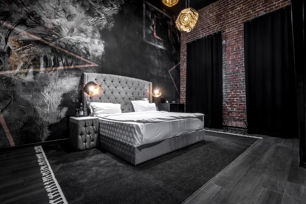 科隆Black Hotels Köln的一间卧室设有一张床和砖墙