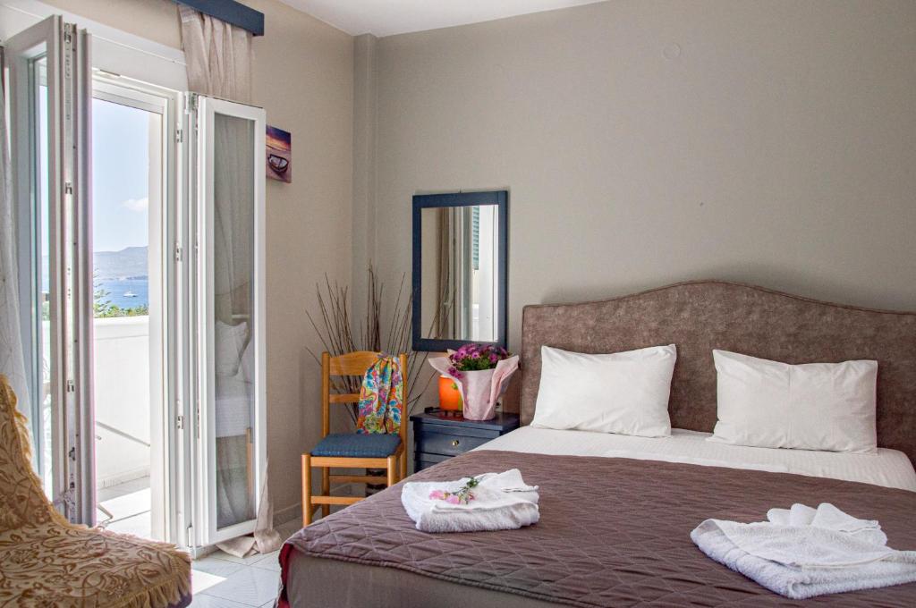 阿达玛斯Christina Rooms的一间卧室配有一张床,上面有两条毛巾