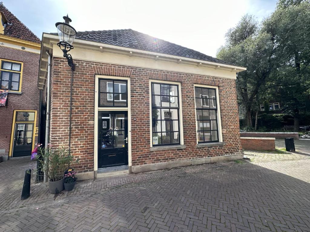 迪温特Luxe Loft in Historisch Pand in Walstraat Deventer的砖砌的建筑,设有黑色的门和窗户