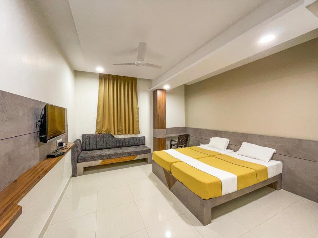 普杰Hari Om Residency的一间卧室配有一张床、一台电视和一张沙发