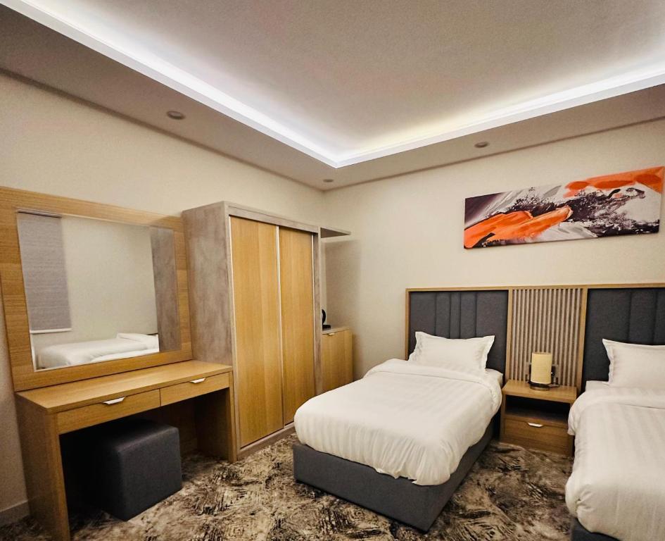 麦地那أجنحة هدوء وصول ذاتي的酒店客房,设有两张床和镜子