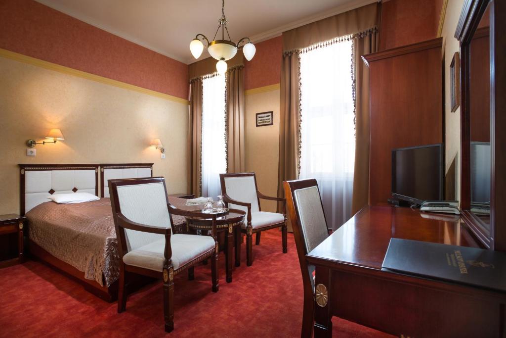 豪伊杜索博斯洛尼尔森酒店的酒店客房带一张床、一张桌子和椅子