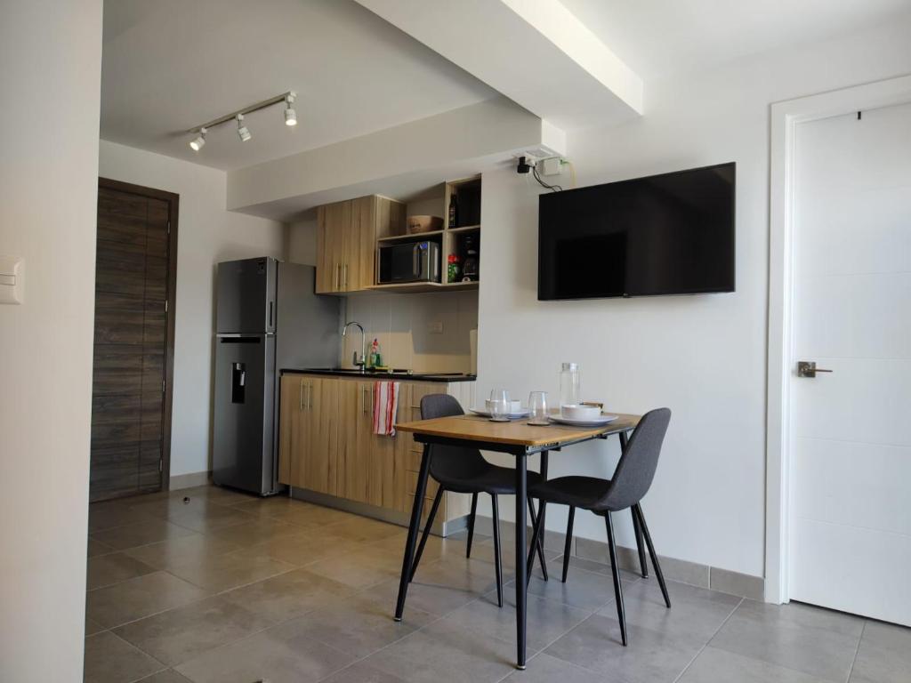 危地马拉Luxury Apartment, 1110 Z.4的厨房配有桌椅和冰箱。