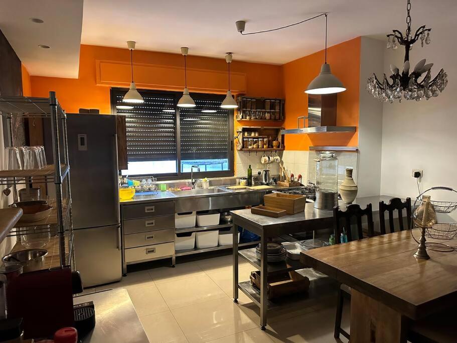 Ash ShumaysānīDiplomatic apartment area的一个大厨房,设有橙色的墙壁和桌子