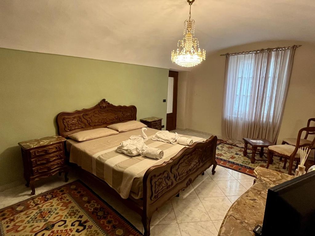 Chiusa di PesioCasa dell’Annunziata的一间卧室配有一张大床和一个吊灯。