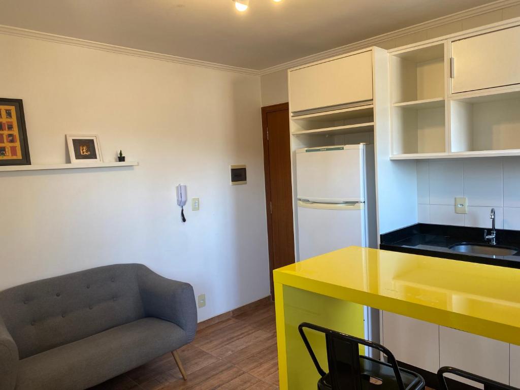 约恩维利Studio Minimalista Região Central Residencial Padre Kolb 201C的厨房配有黄色台面和沙发