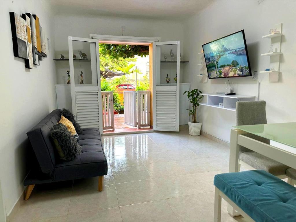 卡塔赫纳apartamento Ana ciudad amurallada的带沙发和滑动玻璃门的客厅