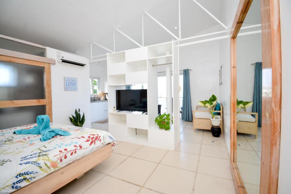长滩岛Babosam Apartments的一间卧室配有一张床,并在一间客房内配有电视。