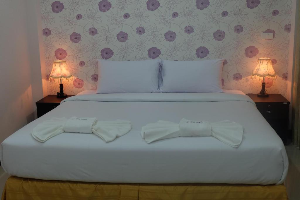 塔可克海滩Tubkaek mansion的卧室配有带两盏灯的白色床
