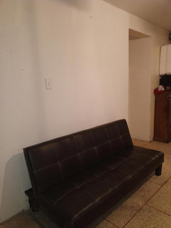 加拉加斯Como en Casa的客厅里一张黑色真皮沙发