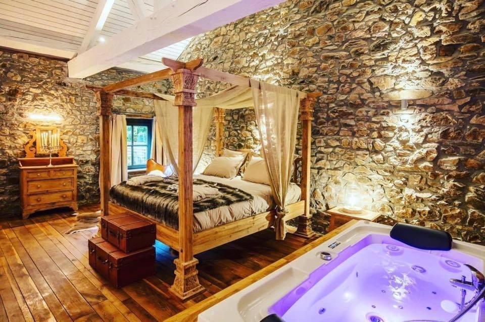 埃尔泽Le Sanglier Amoureux的一间卧室配有一张床和一个浴缸
