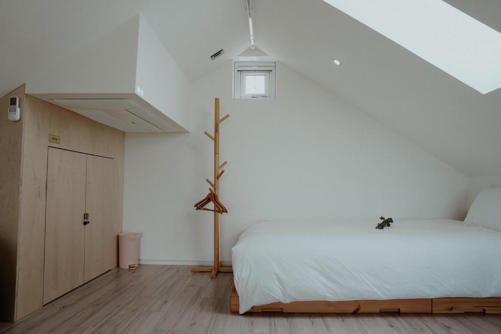 济州市Dalthor Pension的一间卧室设有一张床和白色的墙壁