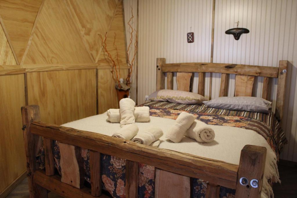 科伊艾科Lerun Sheg Lodge的一间卧室配有一张带毛巾的木床