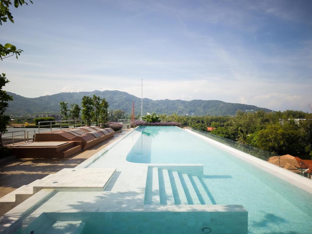 邦涛海滩Skypark Laguna apartments Bangtao的一个带椅子的游泳池,背景是山脉