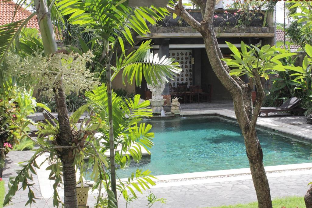 勒吉安芒加巴厘岛酒店的花园中树木繁茂的游泳池