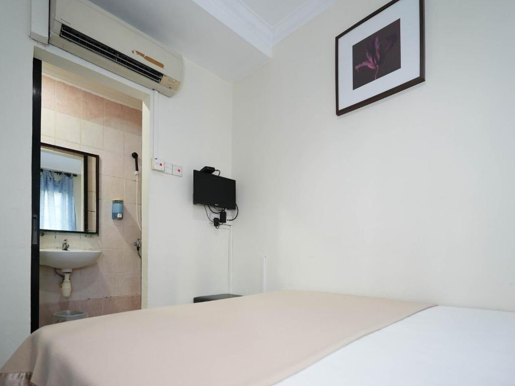 新加坡Amrise Hotel, Check in at 10PM, Check out at 9AM的白色的客房设有床和水槽